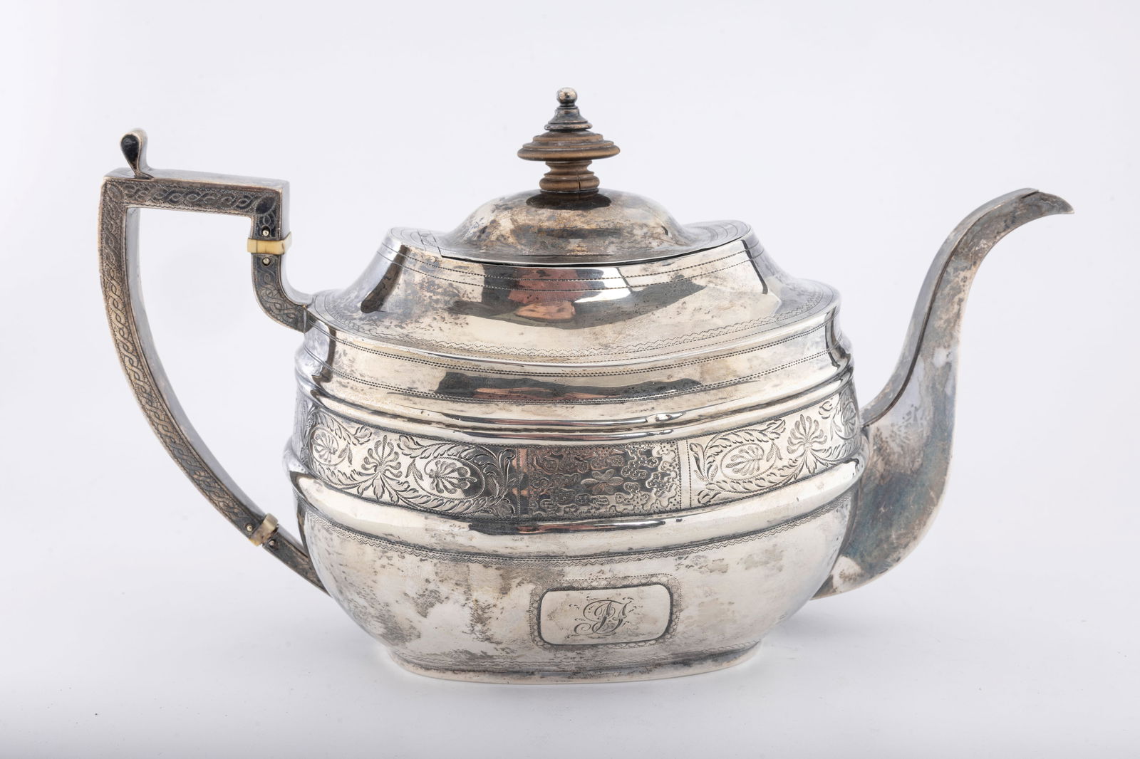 A GEORGIAN SILVER TEAPOT BY NAPHTALI HART & DUNCAN URQUHART LONDON 1789: Traditional form. Some loss to the bone and chips to the wood. Naphtali Hart was England's first known Jewish silversmith. He worked into the 19th c with his partner and later on his own. He died in 1
