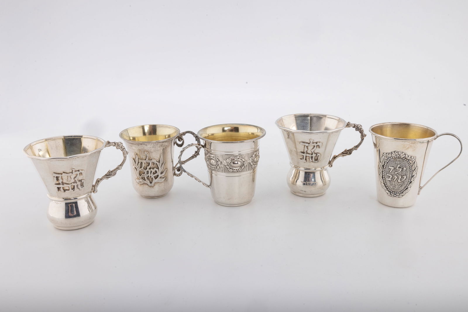 A GROUP OF FIVE "YELED TOV" STERLING SILVER CUPS: 2" or larger each. Minor dents. Total weight 173 grams