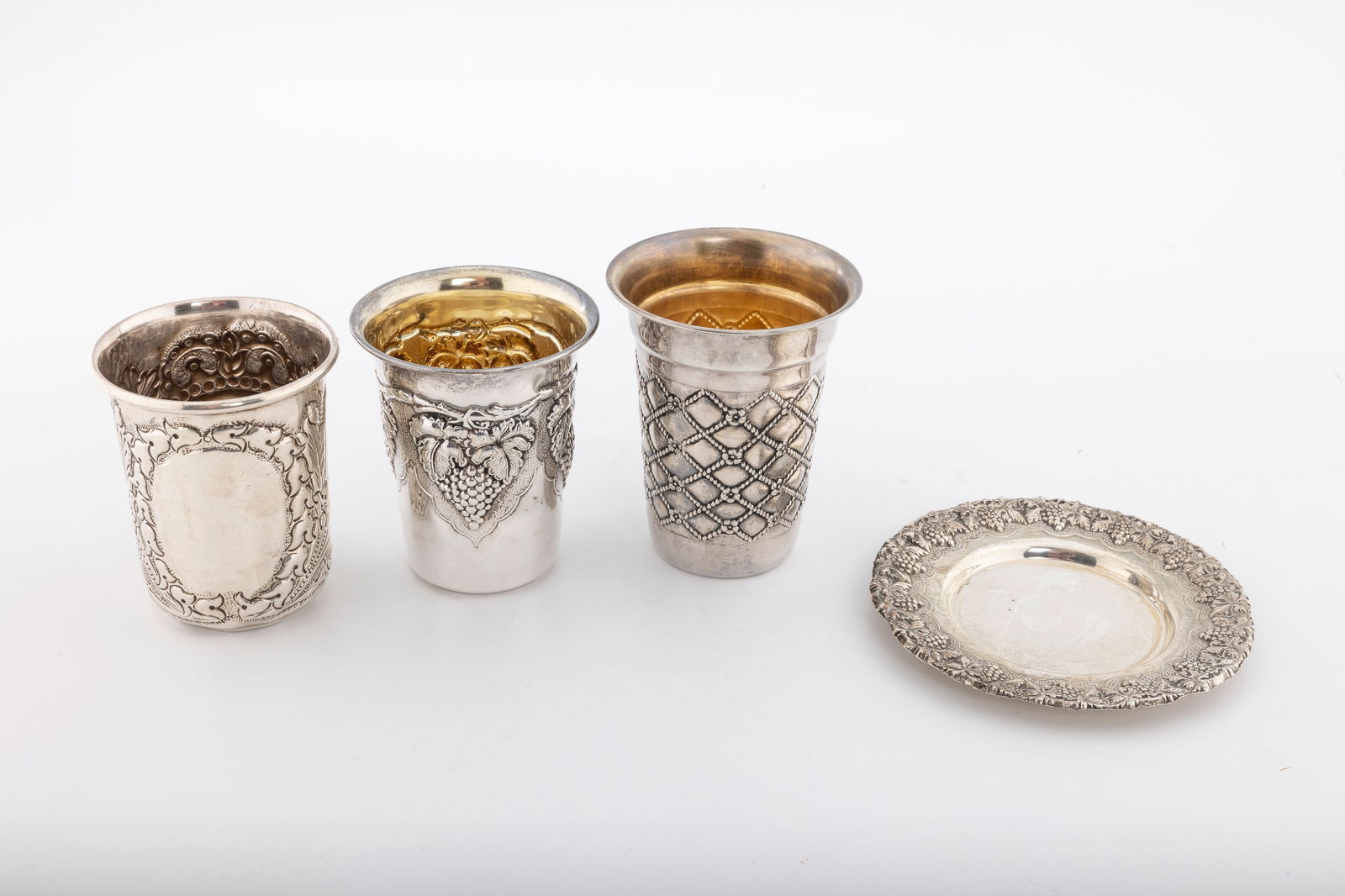 A GROUP OF THREE STERLING SILVER KIDDUSH CUPS: Beaker form. One with a matching plate. Total weight is 190.5 grams.