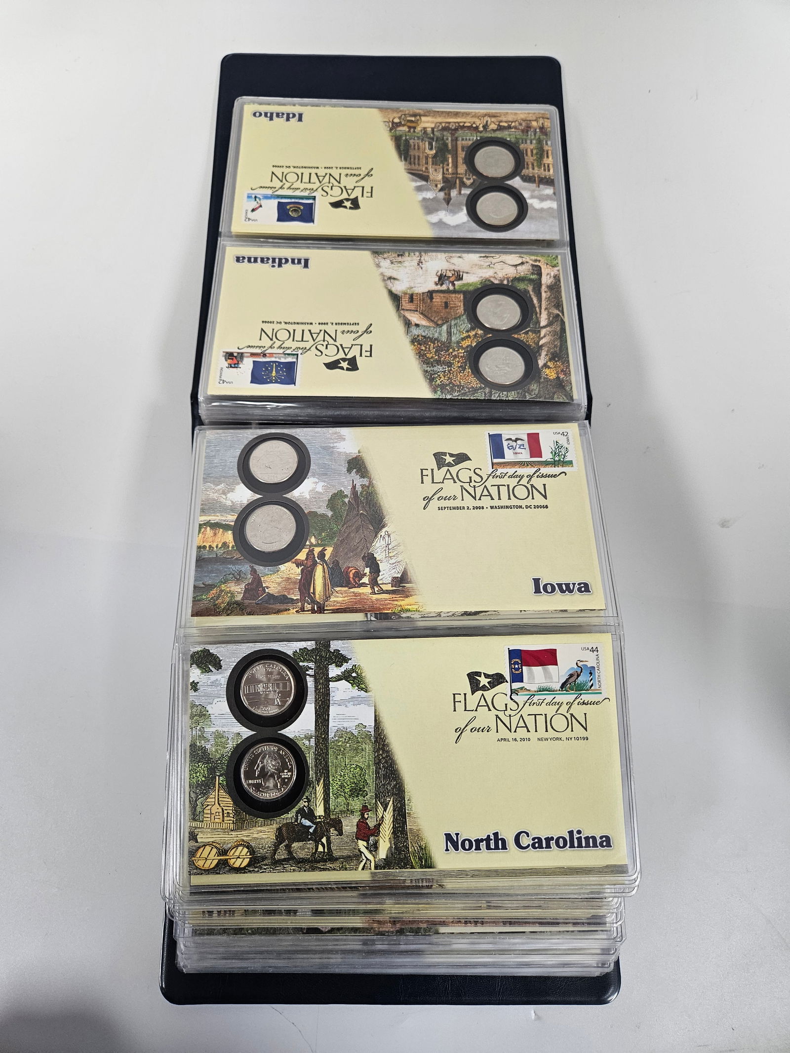 FLAGS OF OUR NATION - STATE FLAGS IN COVERS AND QUARTERS: A collection housed in an lbums of the 50 State quarters mounted in postal covers.