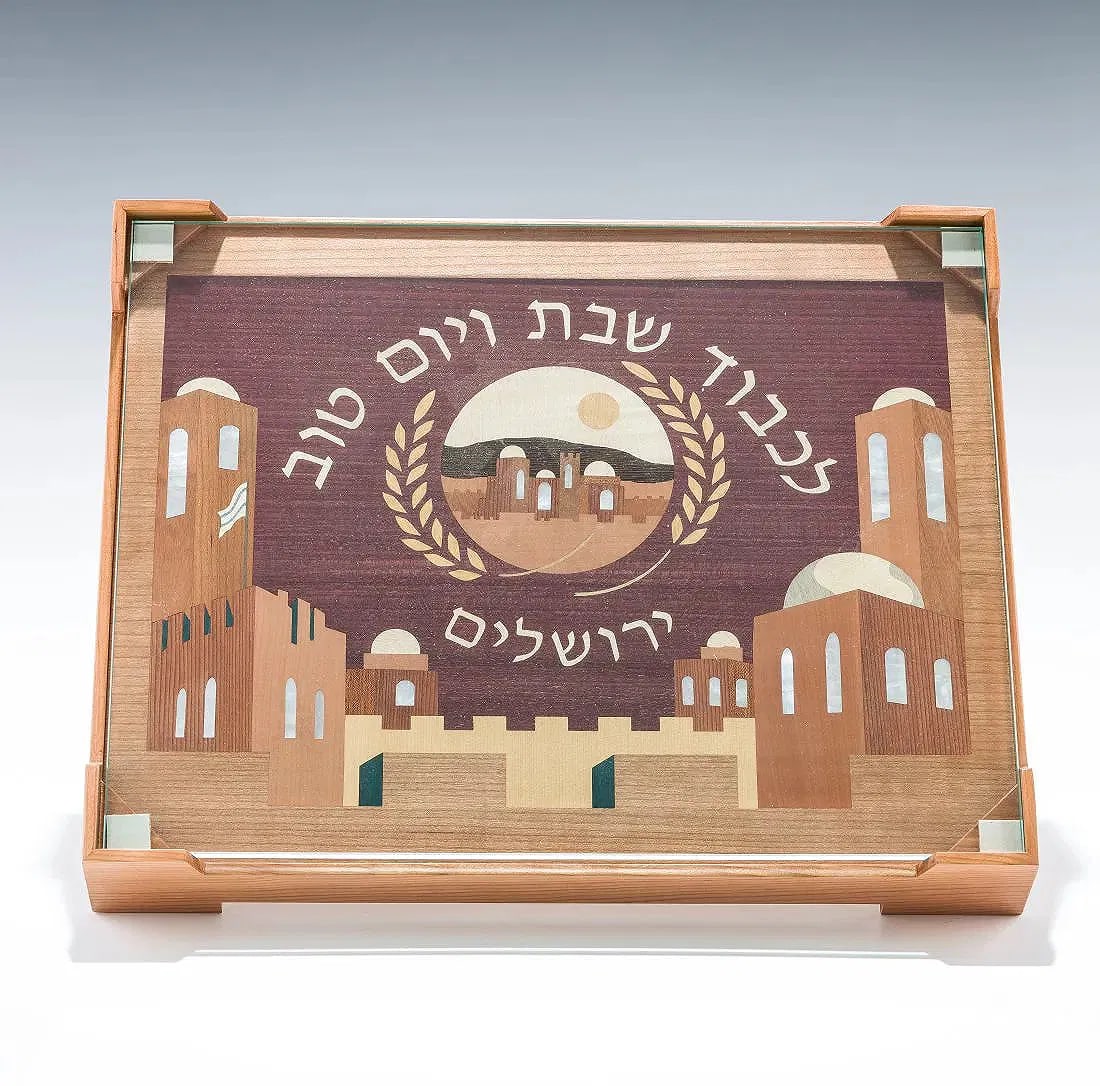 A HAND MADE CHALLAH BOARD BY ALEX AND LORELEI GRUSS. Brooklyn, NY 2021.: Hand crafted with multiple colors of wood, a cherry wood frame and tempered glass. Central scene of the Old City of Jerusalem and IN HONOR OF THE SABBATH AND YOM TOV. 16" x 13".