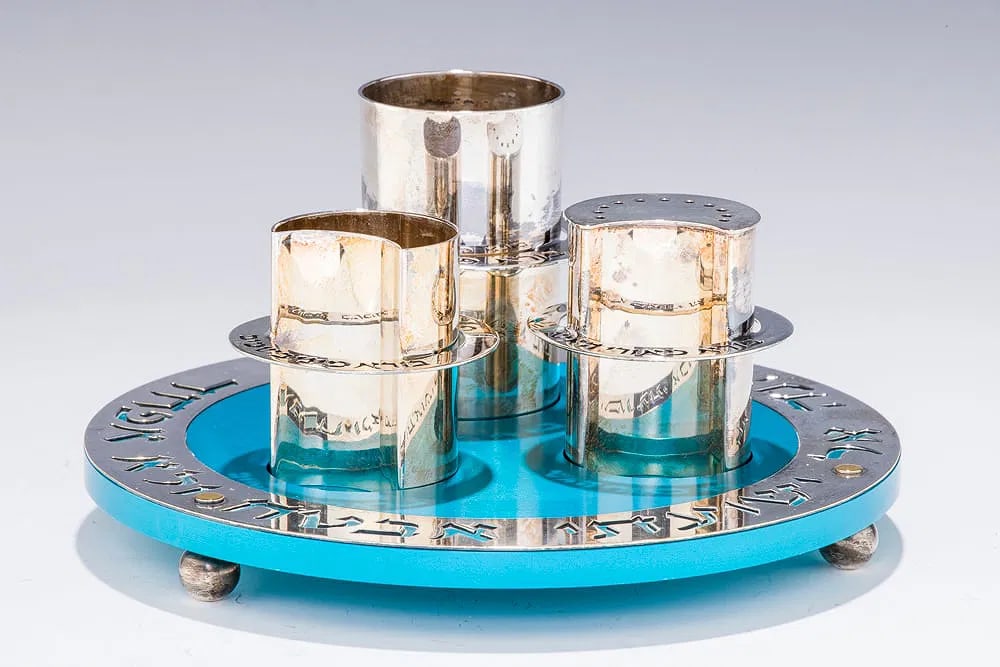 A STERLING SILVER AND ANODIZED BLUE ALUMINUM HAVDALLAH SET BY RAFI LANDAU: Israel, c. 2010. On balled feet with a sterling silver candle holder, spice box and large cup. 7.9" wide.