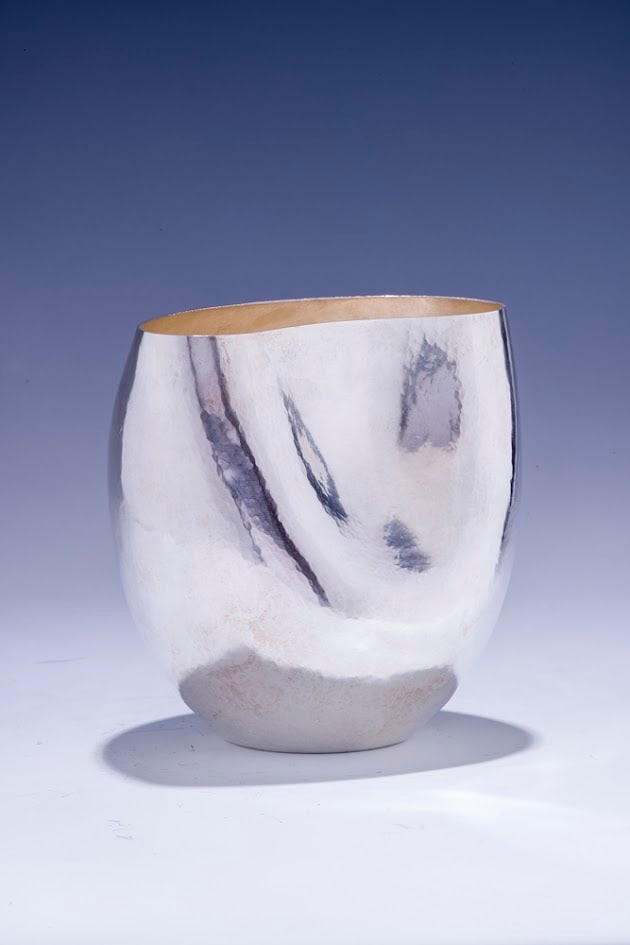 A HAND WROUGHT STERLING SILVER WASHING CUP BY YONATAN SHALOM: Gush Etzion, modern. Hand wrought with a soft hand hammered finish in modernist design. 5" tall.