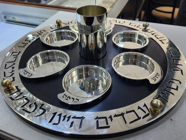 A STERLING SILVER AND ANODIZED ALUMINUM PASSOVER SEDER PLATE BY RAFI LANDAU: Israel, c.2010. With dishes for the traditional Passover foods and a cup of Elijah. The outer rim is engraved with Passover related sayings. 18” wide.