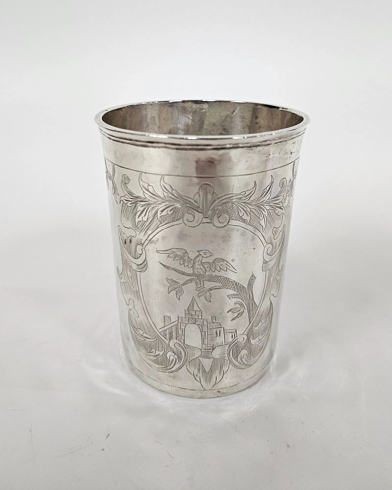 AN ANTIQUE SILVER CUP. Russia, 1775: Beaker form. Engraved with town scenes, cartouches, and scrolling. Marked. 3.5" tall and 2.935 ozt.