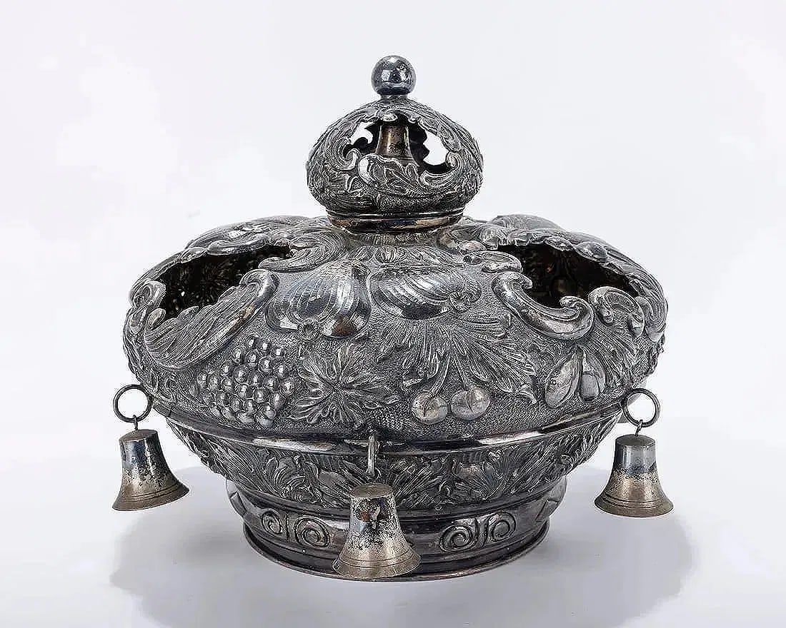 A LARGE AND IMPRESSIVE SILVER TORAH CROWN. Hungarian, 20th century.: A SILVER TORAH CROWN. Hungarian, 20th century. Chased with fruits, scrolls and other organic designs. Fitted with six large silver bells. Inscribed with Hebrew dedication. 11" wide. Similar sold: J. G