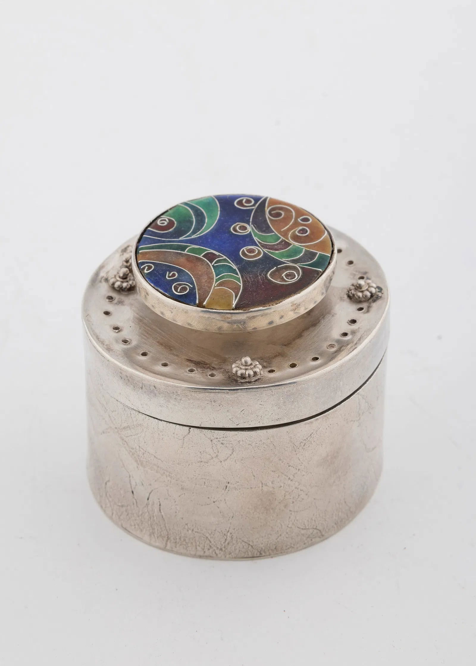 A STERLING SILVER SPICE CONTAINER BY ILANA RAPPAPORT. American, c. 1990: Circular in form. the upper portion pierces and decorated with an enamel mosiac. 2.4" wide and 153.8 grams