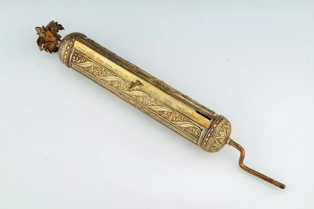 A LARGE SILVER MEGILLAH CASE WITH ORIGINAL MEGILLAH. Ottoman Empire, c. 1880: A LARGE SILVER MEGILLAH CASE WITH ORIGINAL MEGILLAH. Ottoman Empire, c. 1880. Hand chased with decorative flowing design. Gilded. With a solid turn handle and flower finial. 13" long.