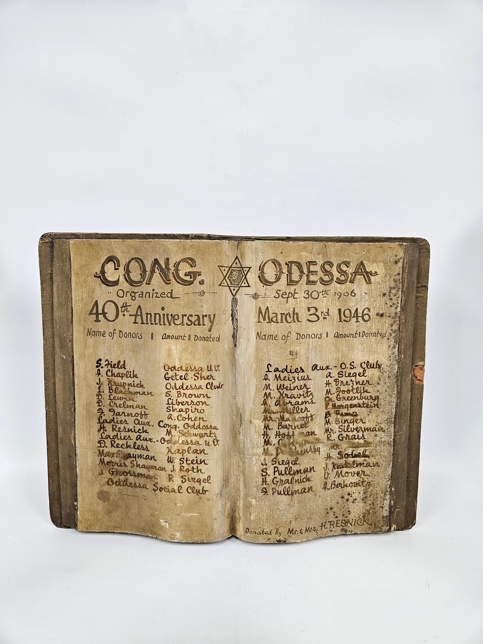 A PAINTED WOODEN DONATION PLAQUE FOR CONGREGATION ODESSA. New York, 1946. In the shape of a book. Pa: A PAINTED WOODEN DONATION PLAQUE FOR CONGREGATION ODESSA. New York, 1946. In the shape of a book. Painted with the list of donors giving donations in honor of the fourtieth anniversary of the shule. 1
