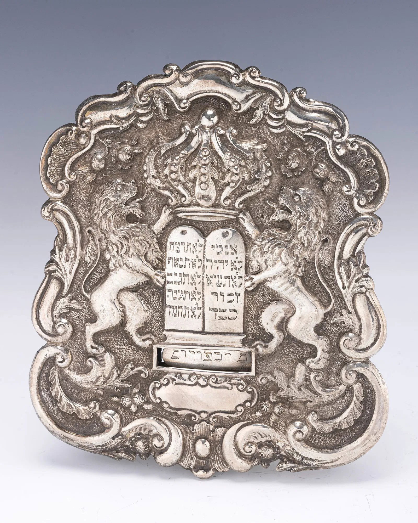 A SILVER TORAH SHIELD. Vienna, c. 1880.: A SILVER TORAH SHIELD. Vienna, c. 1880. Traditional form. Decorated with two lions flanking a decalogue under a crown. 8.2” tall.