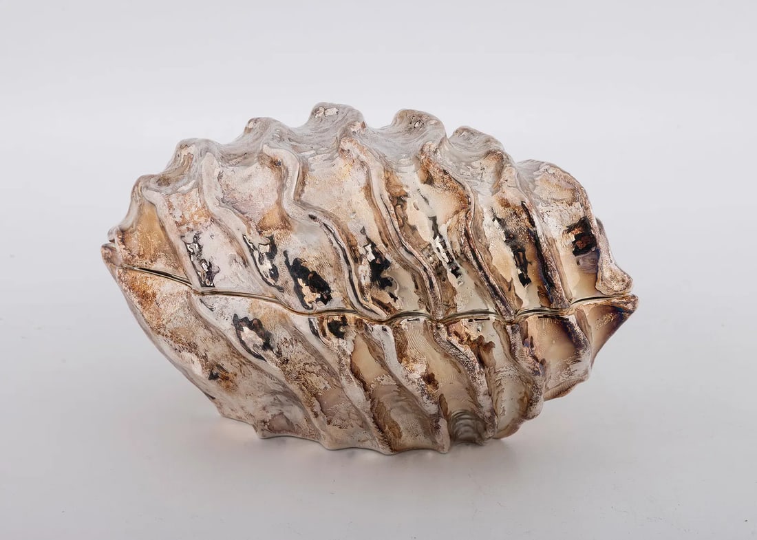 A STERLING SILVER ETROG CONTAINER BY PAMPALONI SILVERSMITHS. Firenze, modern.,: Oval in form. With wave design from the "ashur" series. 7" long and 492 grams. With the original presentation box.