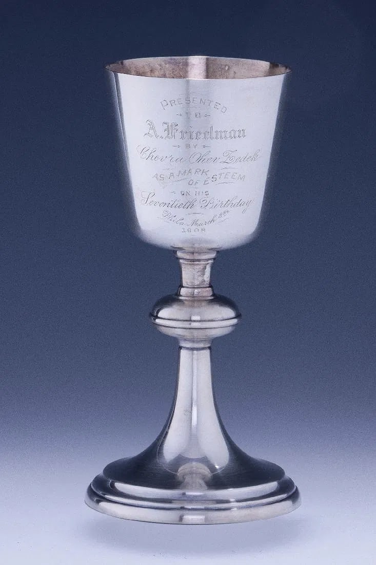 A LARGE WHITE METAL SYNAGOGUE KIDDUSH GOBLET BY GORHAM.: American, 1908. Engraved Presented to A. Friedman by Chevra Ohev Zedek as a mark of esteem on his seventieth birthday, Phila. March 8th 1908. Ohev Zedek was founded in Philadelphia in 1889 and merged 