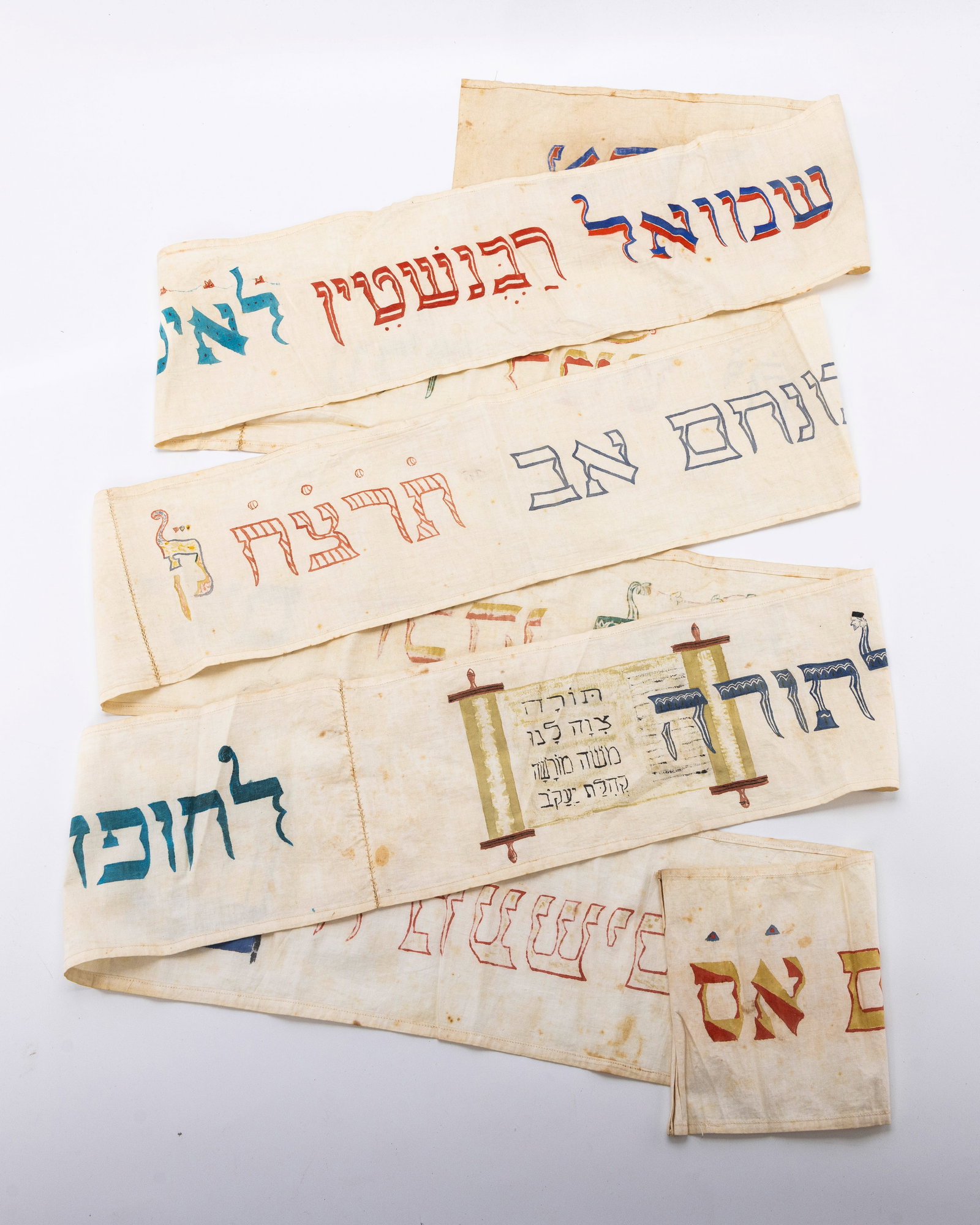 A LINEN TORAH WIMPLE. Germany, 1935.: On a white linen base. Embroidered with the name of the boy that who's bris it was as well as blessings and the year.