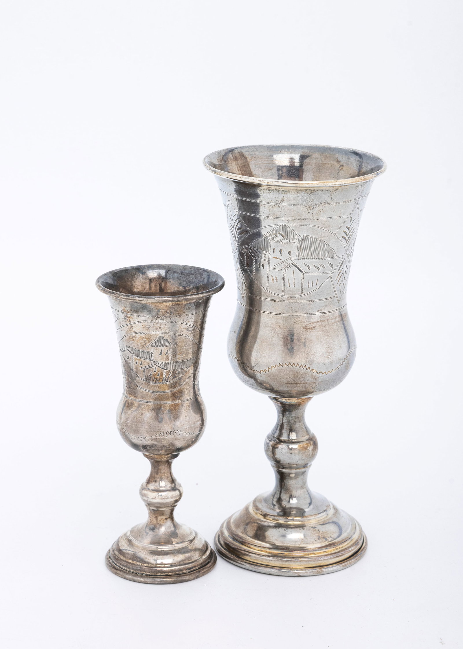 TWO STERLING SILVER KIDDUSH CUPS. American, c. 1920: By Russian silversmiths. The first one is 5.7" tall and the shorter one is 4.2" tall. Total weight is 147.9 grams.