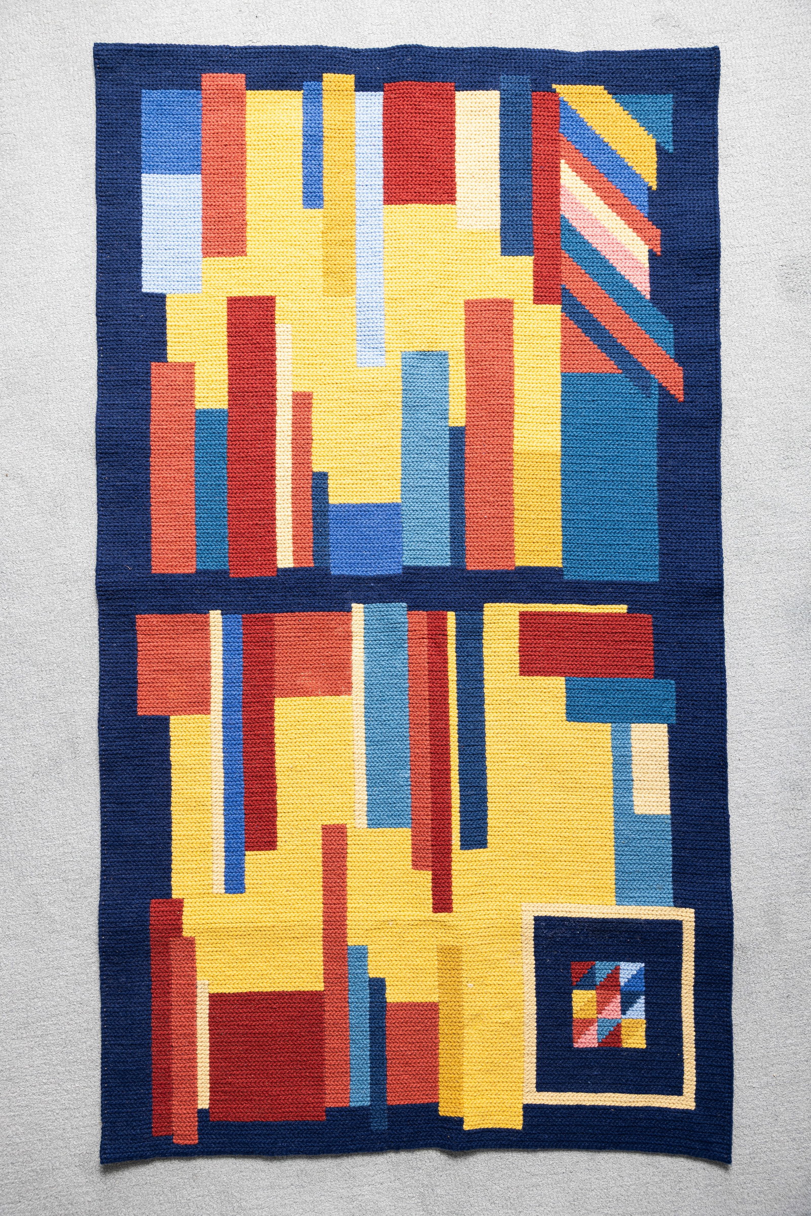MID CENTURY CASA DOS TAPETES DE ARRAIOLOS RUG. Portugal: Hand woven textile meant for awall hanging in geometric abstract design influence by cubism. With orignal label.Polychrome geometric design produced for the European market. 53" x 30".