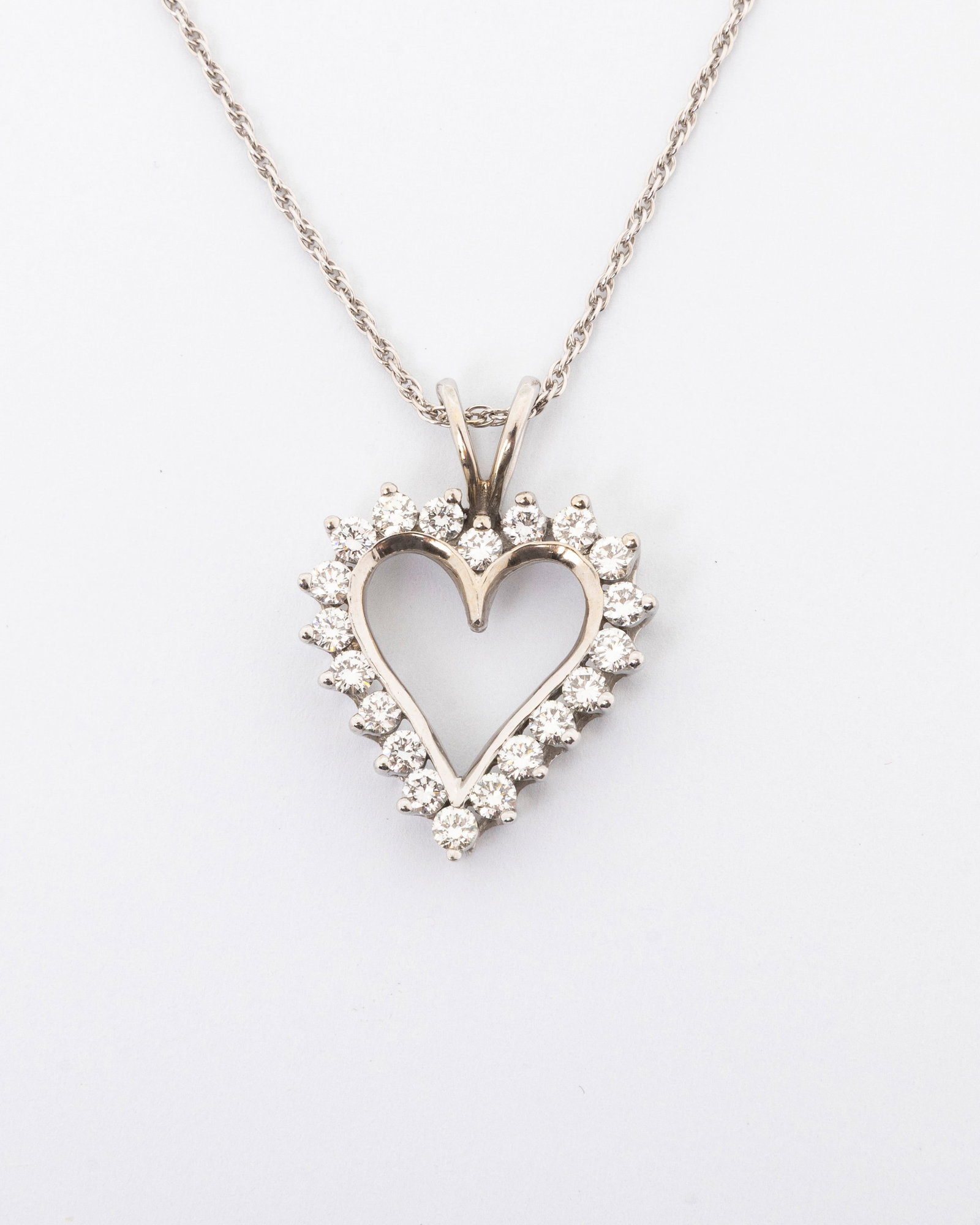 A 14K HEART PENDANT WITH DIAMONDS with original chain: 1.5 Karat total weight. Heart shaped pendant with the original chain. 4.2 dwt.