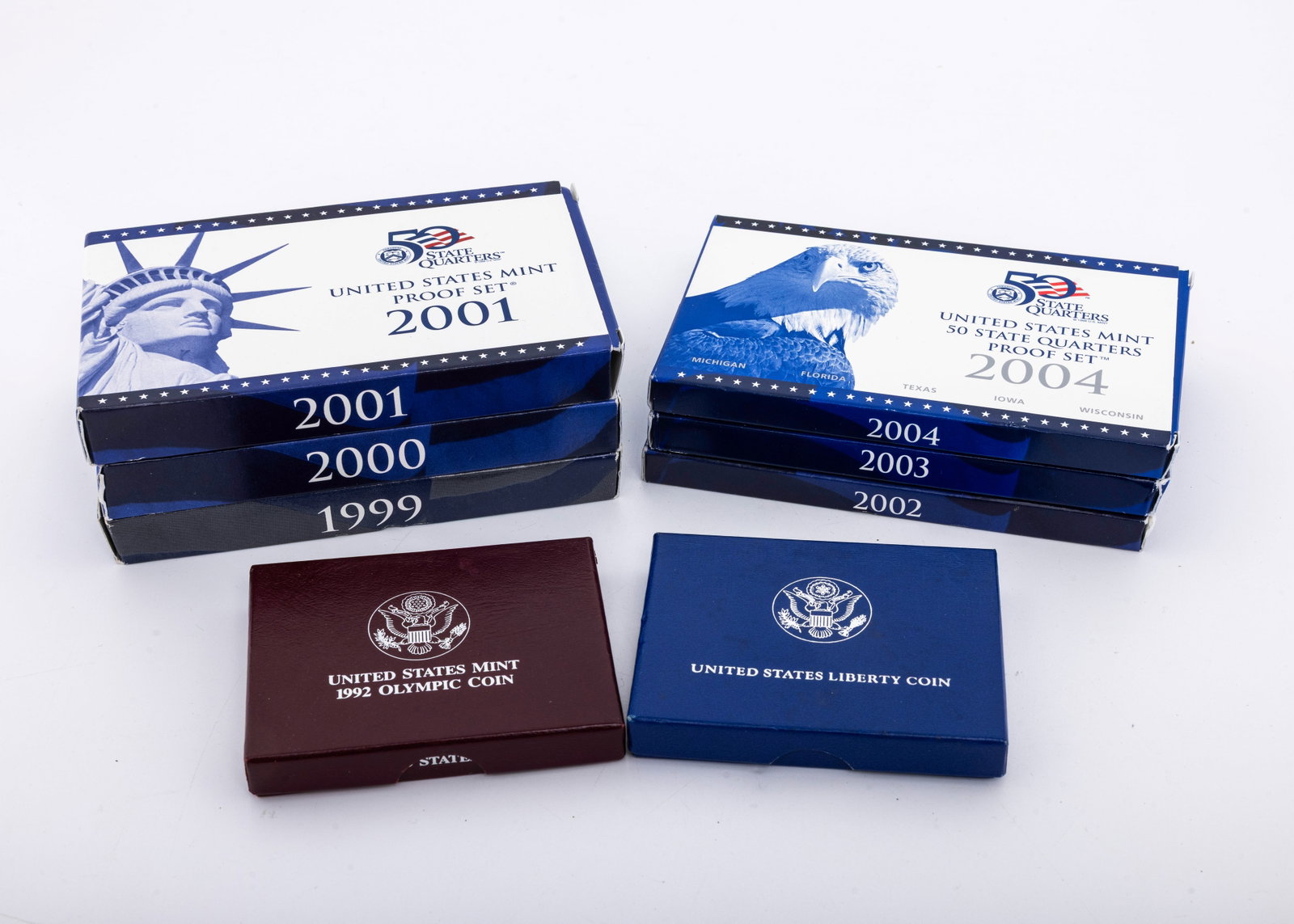 A GROUP OF UNITED STATES PROOF SETS - FIFTY STATE QUARTER SERIES: Including 1999, 2000, 2001, 2002, 2003 AND 2004. Accompanied by and uncirculated liberty coin and a proof 1992 Olympic coin.