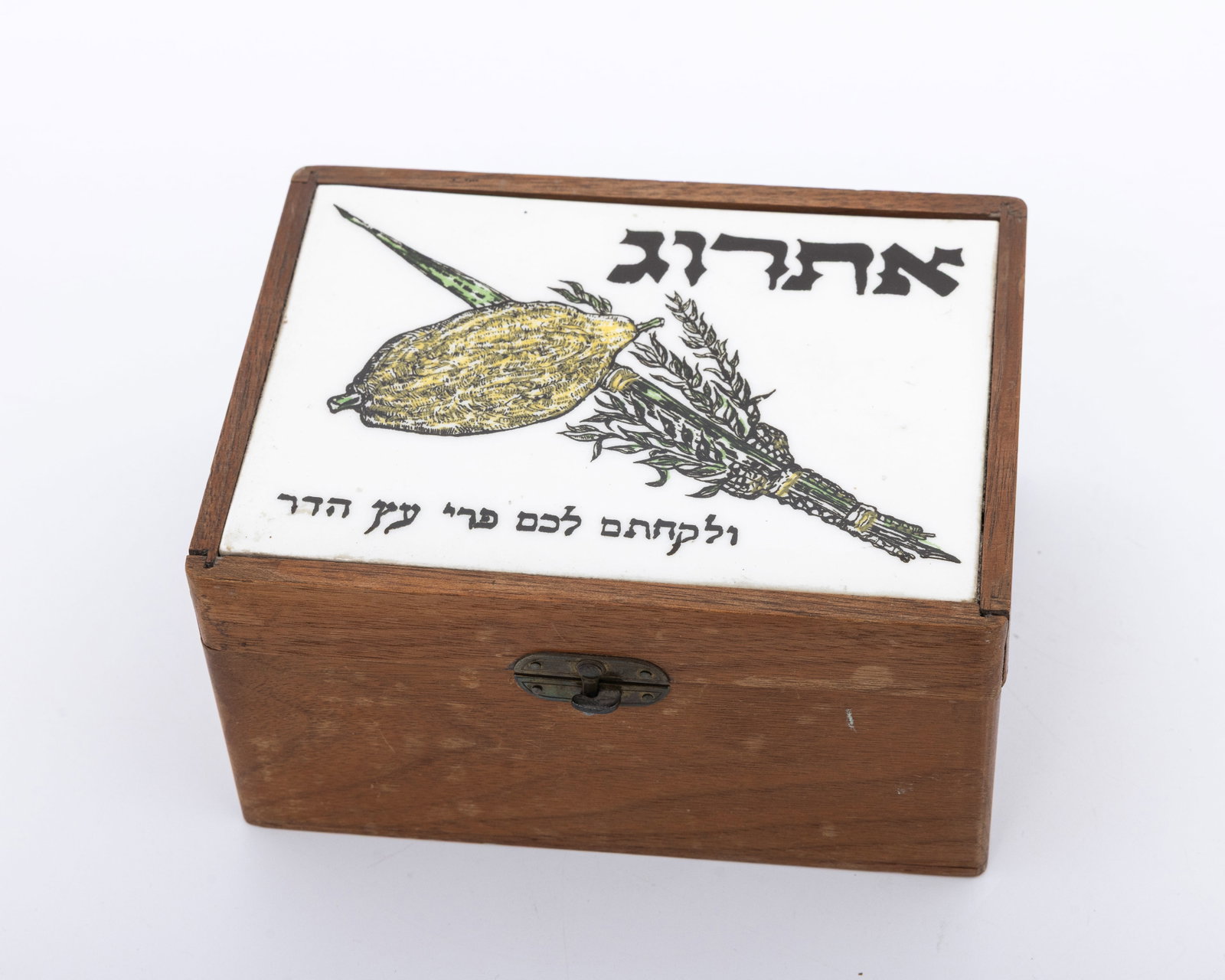 AN VINTAGE ARTISAN ETROG BOX. Probably Israel, c. 1950: Rectangular form. Made of wood with decorative Porcelain lid with passage relevant to the Succoth holiday. 6.5" x 4.8".