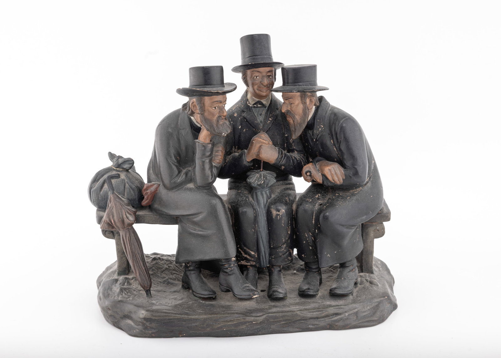 A LARGE FIGURINE OF THREE JEWS IN DISCUSSION. Czechoslovakia, c. 1920: Three orthodox Jewish men sitting in discussion on a park bench. Good condition for age. 10â€? tall. Marked Made in Czecheslovkia and engraved with a serial number.