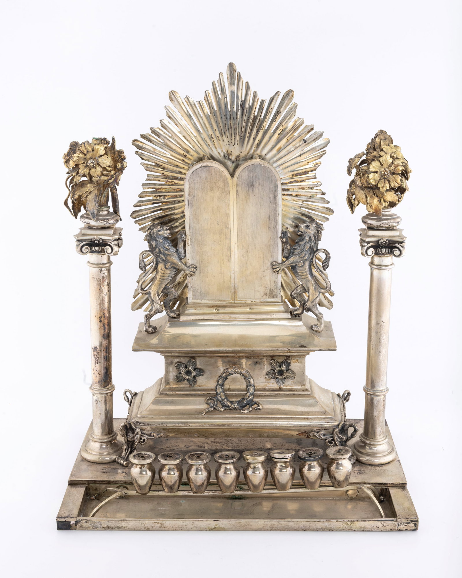 THE PERSONAL HANUKKAH LAMP OF RABBI MORDECHAI SCHRAGA FRIEDMAN, THE FIRST HUSIATYN ROV: Made in Vienna by Vincenz Czokally, c. 1875 - 1880. On a large rectangular base with a step down area that holds the oil section. The body consists of a footed box-like stage that is decorated with fl