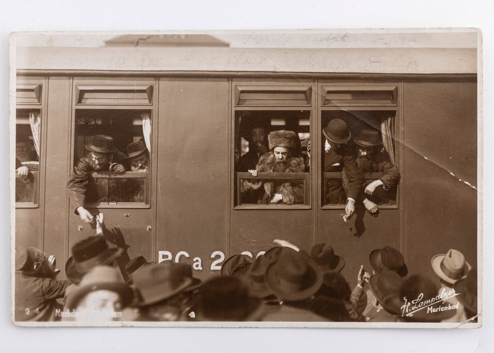 AN ORIGINAL PHOTOGRAPH OF RABBI AHARON ROKEACH OF BELZ ESCAPING THE NAZIS ON A TRAIN. Photographed: An original black and white photograph of the Grand Rabbi of Belz escaping the Nazis on a train. Hans Lampalzer (signed in the plate), a non-Jewish photographer, active in Marienbad, who frequently