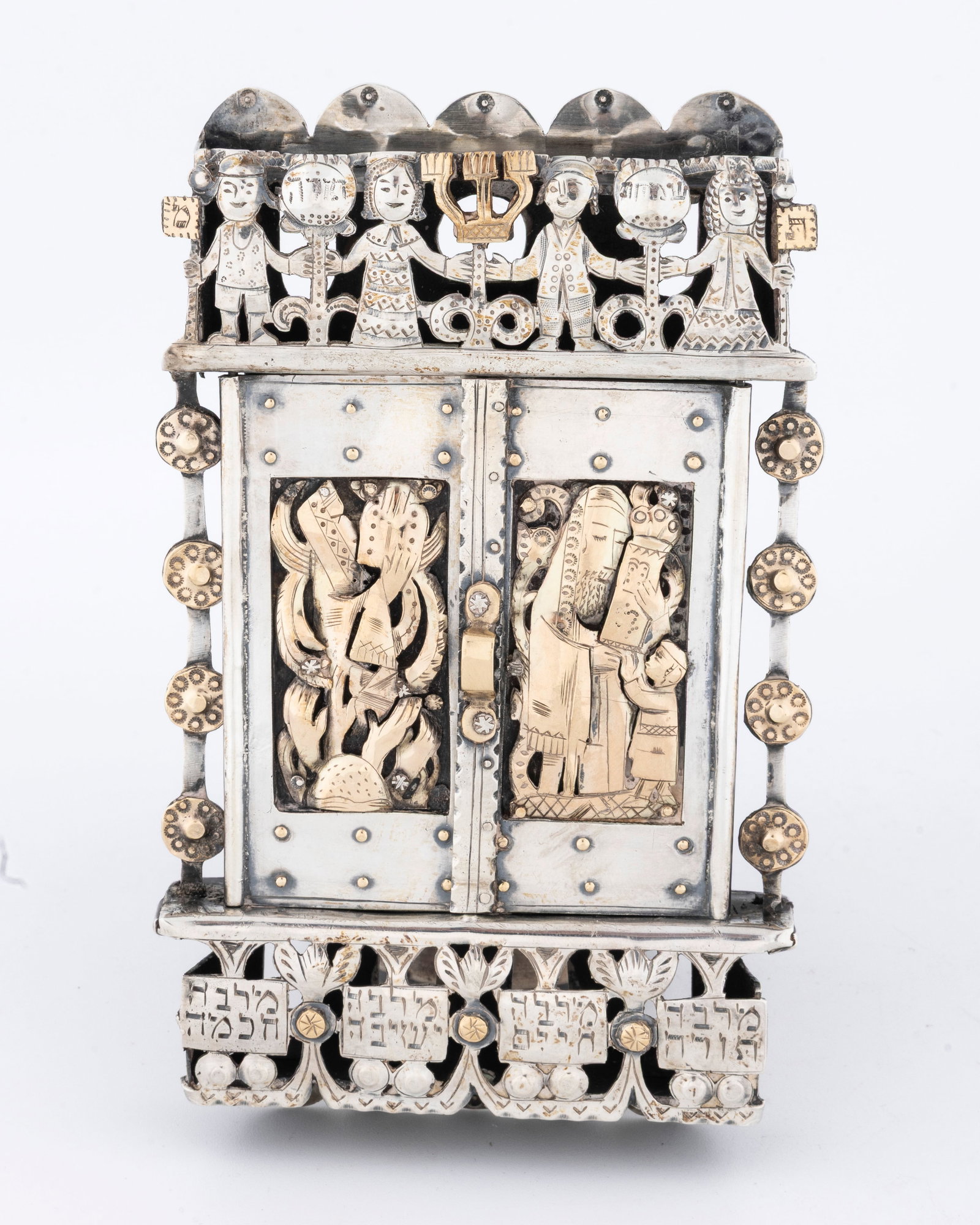 A MAGNFICENT SILVER AND GOLD MEZUZAH BY ILYA SCHOR. New York, c. 1950.: Magnficently crafted. Decorated on the front applied gold depicting with Moshe and the Tablets, and a Rabbinical figure and a young man with a Torah. Further engraved with children holding hands on th