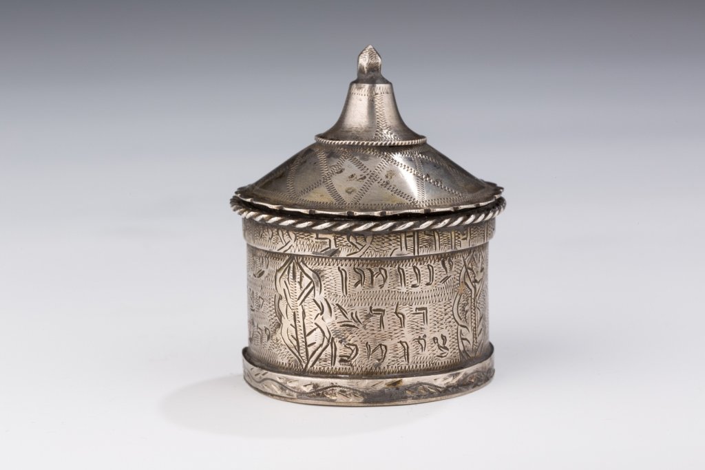 A Silver Amuletic Medicine Container: A Silver Amuletic Medicine Container. Possibly North Africa, 19th century. Cylindrical box and cap with bell-shaped finial, engraved Hebrew inscription with Biblical passage and an apparent request fo