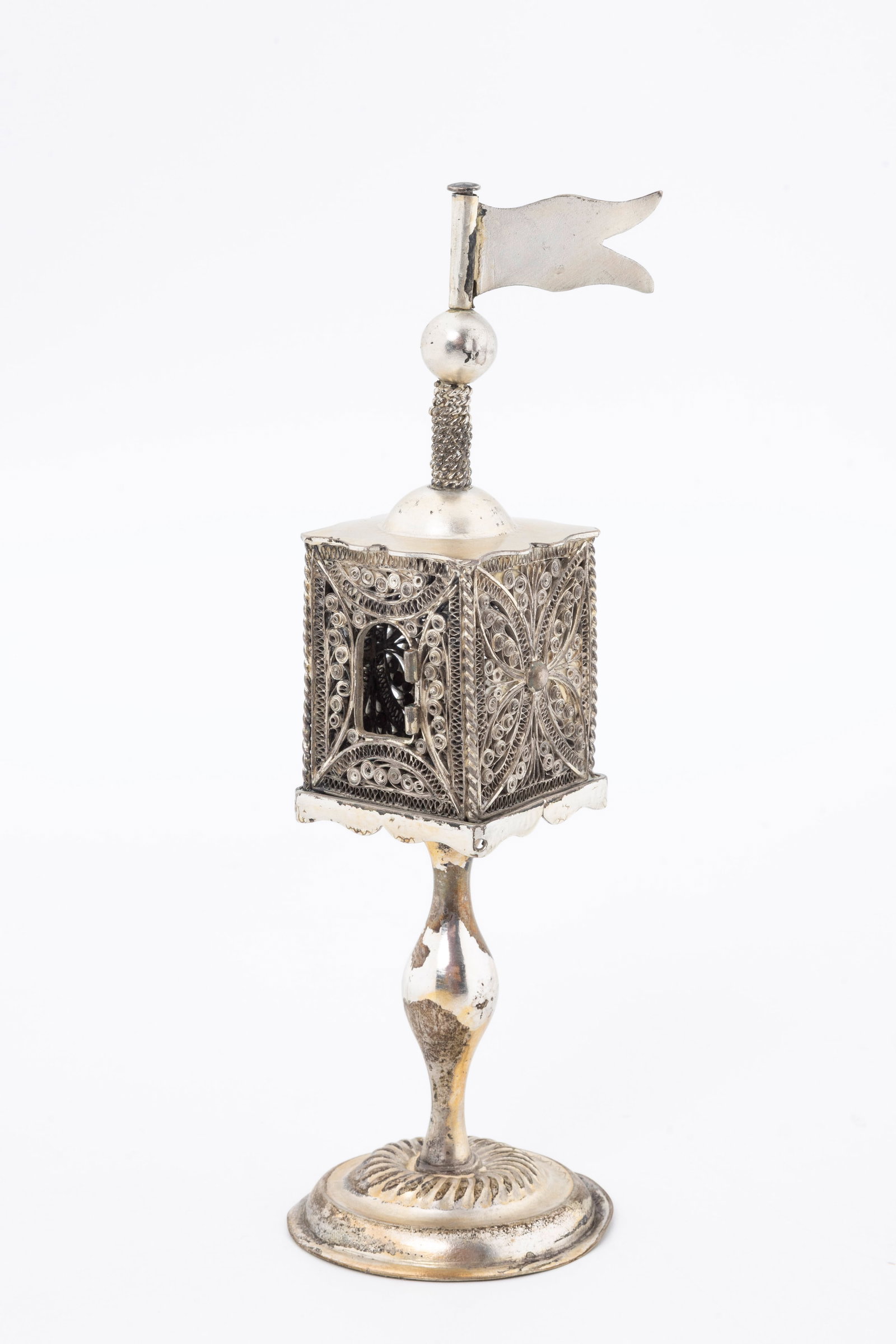 A SILVER SPICE TOWER. Poland or Ukraine, c. 1850.: On a round domed base with baluster shaped stem that connects to a four sided filigree body and topped by a flag. Lacking a door. 6.5" tall and 97.7 grams
