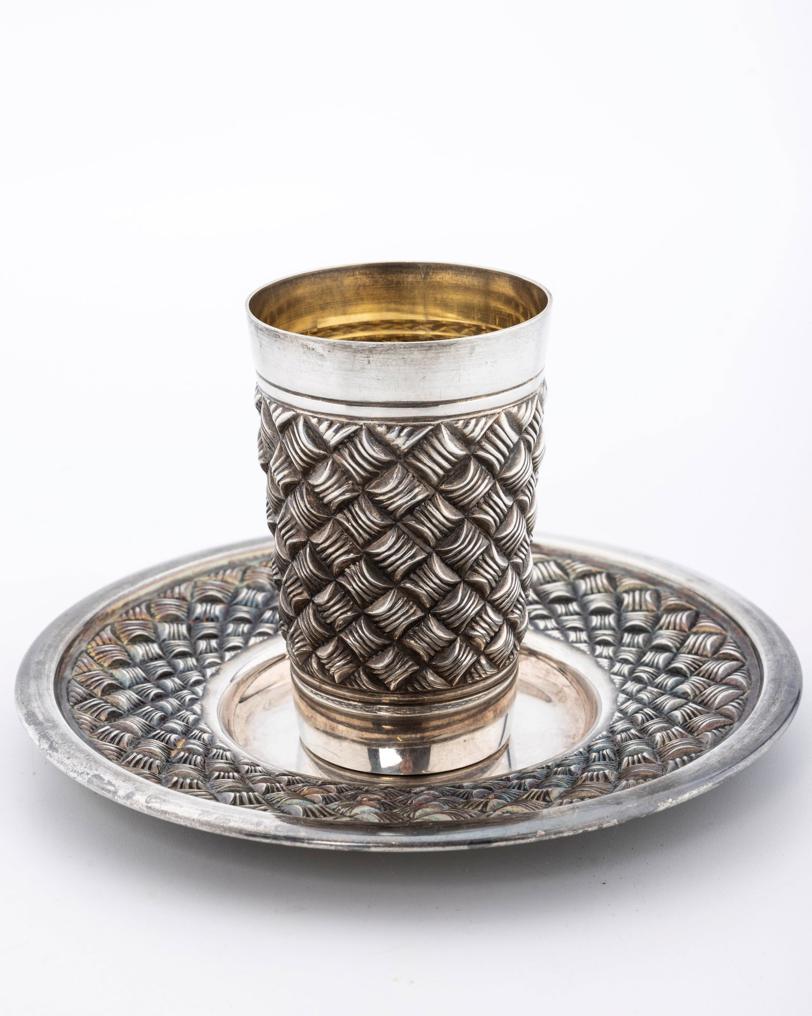 A STERLING SILVER KIDDUSH CUP AND PLATE BY HADDAD BROTHERS.: Israel, c. 2000. In a basket weave design. The cup is 3.9" tall and the plate is 6.5" wide. Total weight is 229 grams.