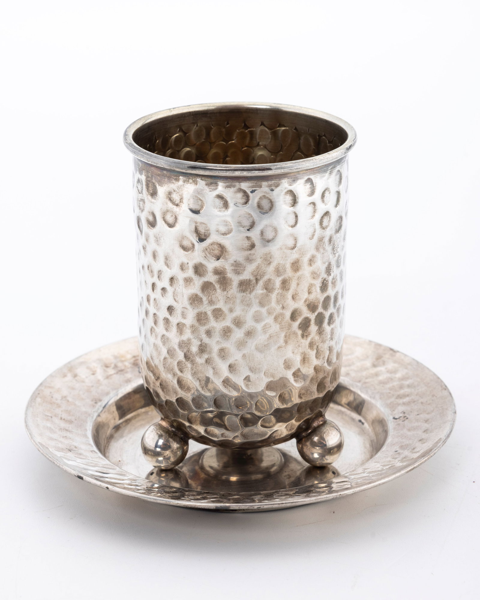 A STERLING SILVER KIDDUSH CUP AND PLATE: Israel, c. 2000. In hand hammered design. The cup is 3.5" tall and the plate is 4.5" wide. Total weight is 122 grams.