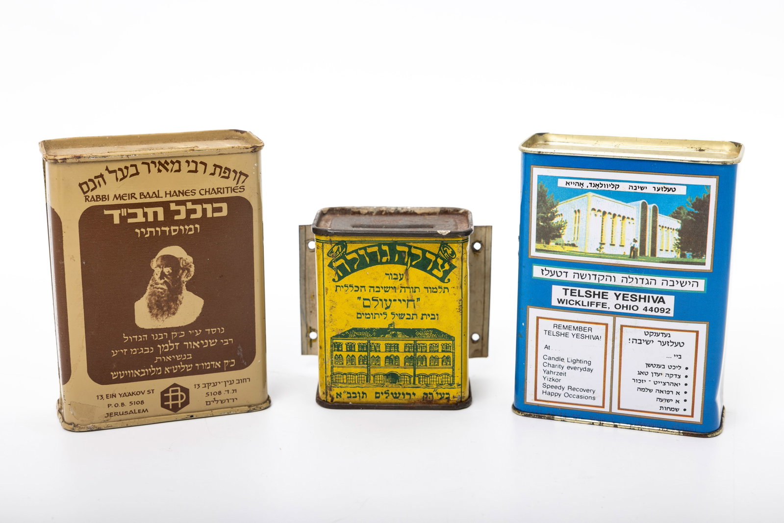 A COLLECTION OF THREE CHARITY CONTAINERS: Collecting funds for Kollel Chabad, Chai Olam Charities in Jerusalem, and the Telshe Yeshiva.