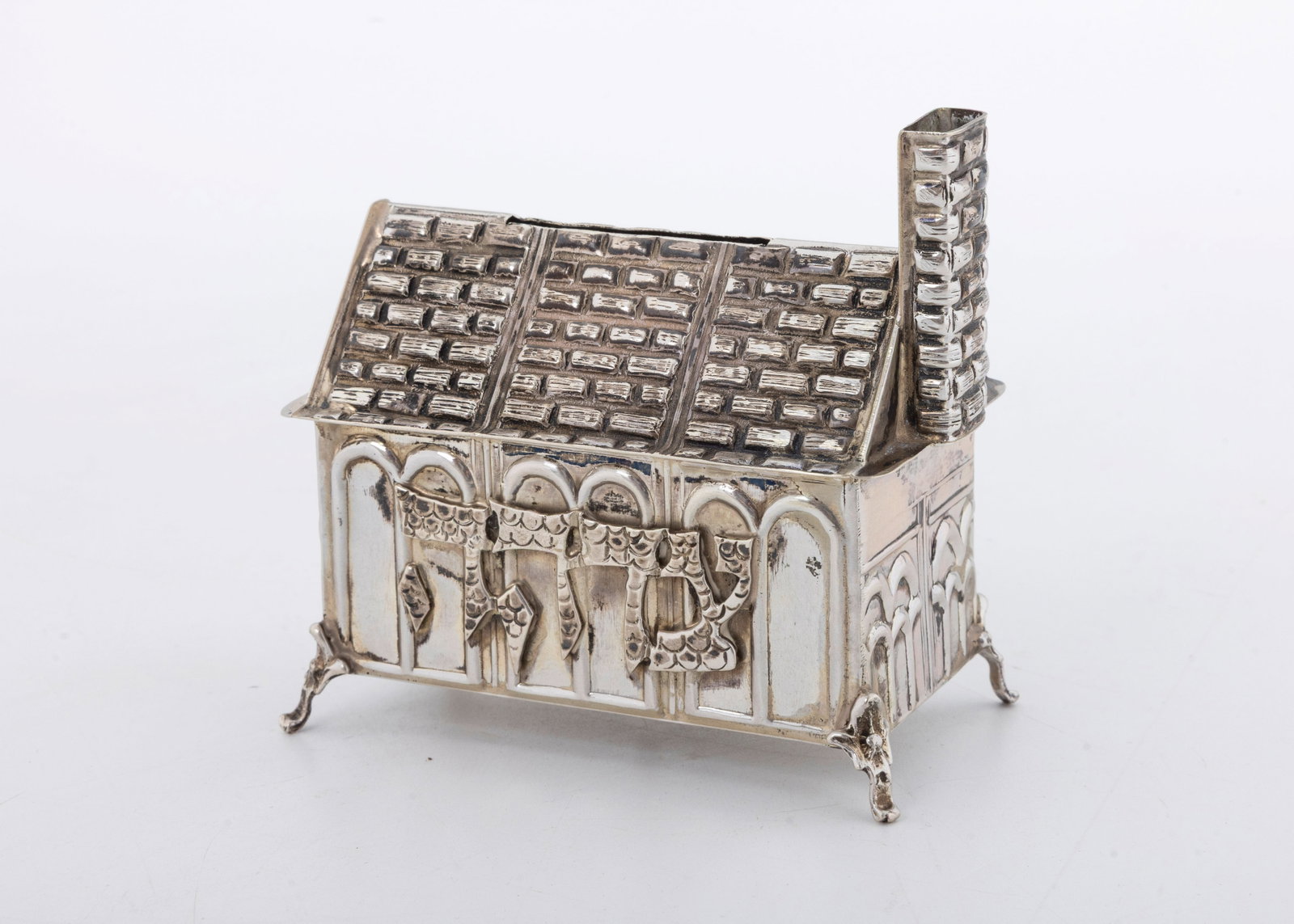 A STERLING SILVER CHARITY CONTAINER. Probably Israel, modern.: In the shape of a synagogue. Engraved with a dedication in Hebrew. Marked sterling. 3.5" wide and 97.3 grams.