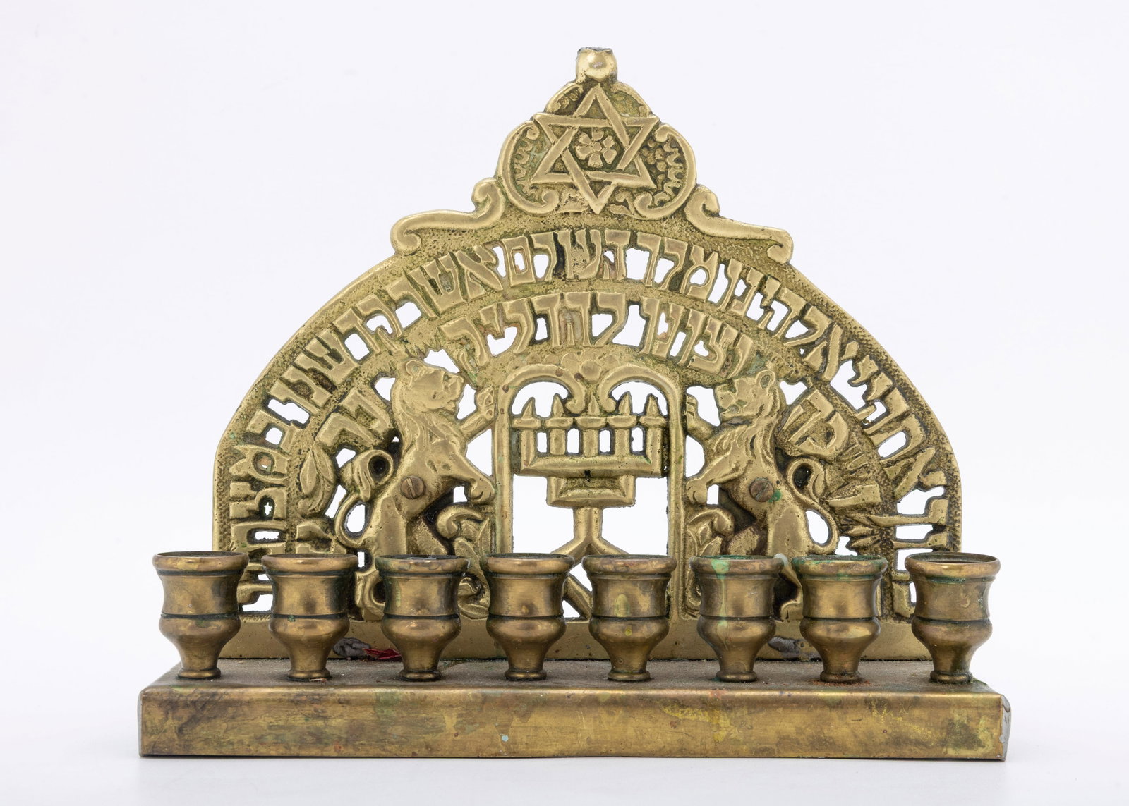 A BRASS HANUKKAH LAMP. Probably USA, early 20th century.: Decorated with two lions, the blessings, a Star of David and a Temple style menorah.
