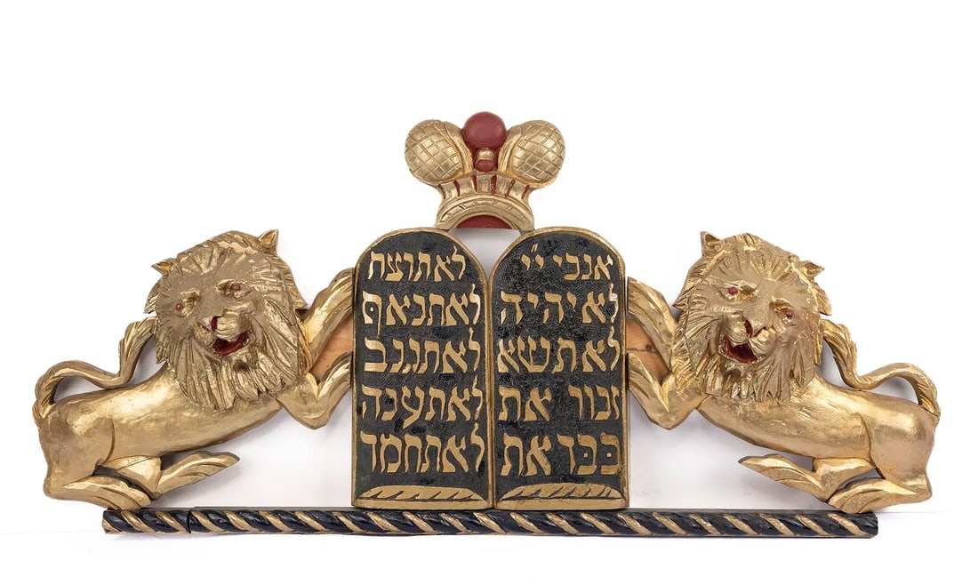 A PAIR OF WOODEN TORAH ARK LIONS. American, early 20th century.: A PAIR OF WOODEN TORAH ARK LIONS. American, early 20th century. Outwardly facing lions that flank a black Decalogue. Topped with a crown and fitted with a twisted base. 43” x 20.”