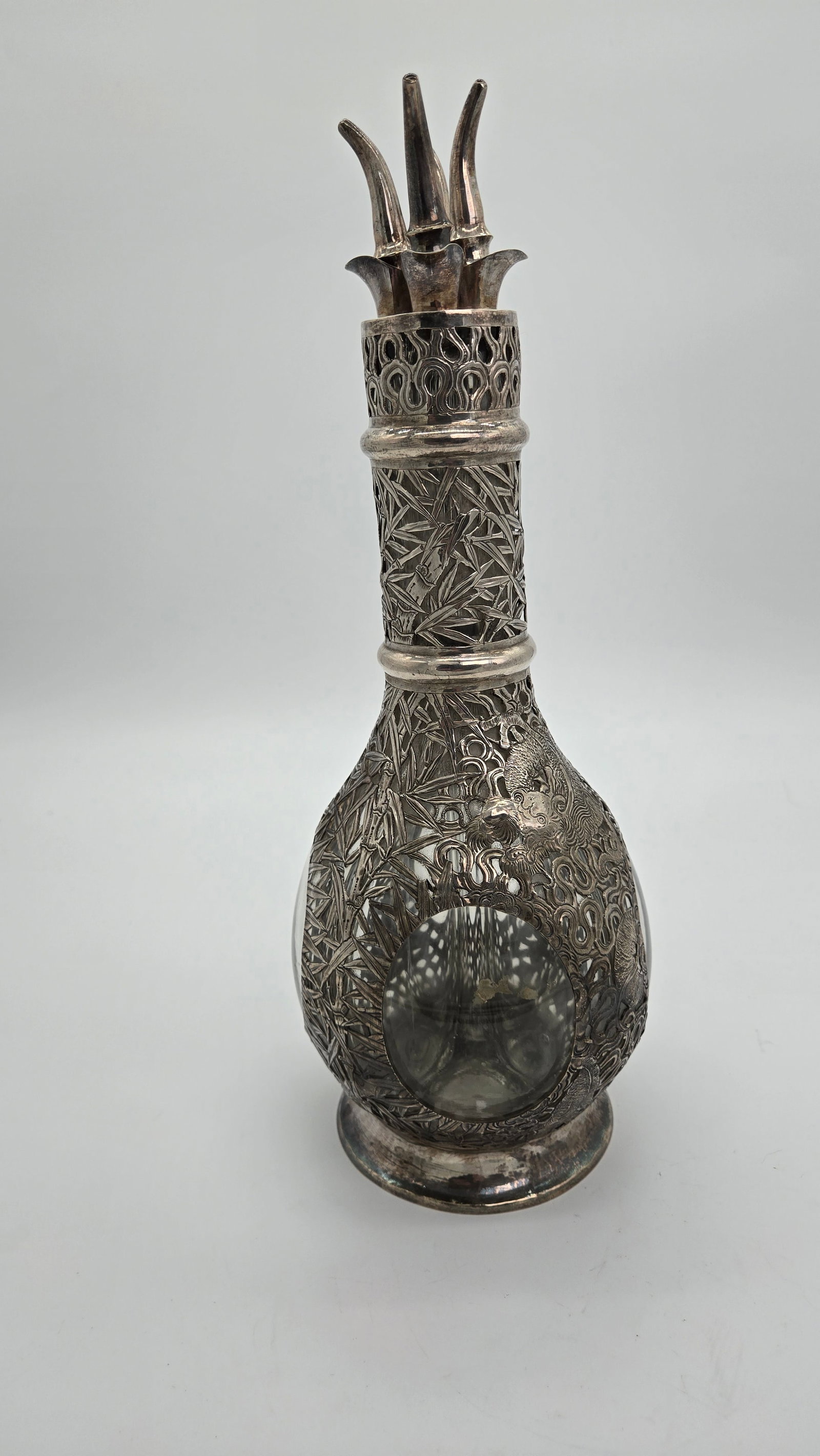 A CHINESE EXPORT SILVER MOUNTED/OVERLAID FOUR PART GLASS DECANTER.: c. 1900. With a unique multi-spout top with four seperate silver stoppers. Made in Chine about 120 years ago, for the Western market. 14" tall