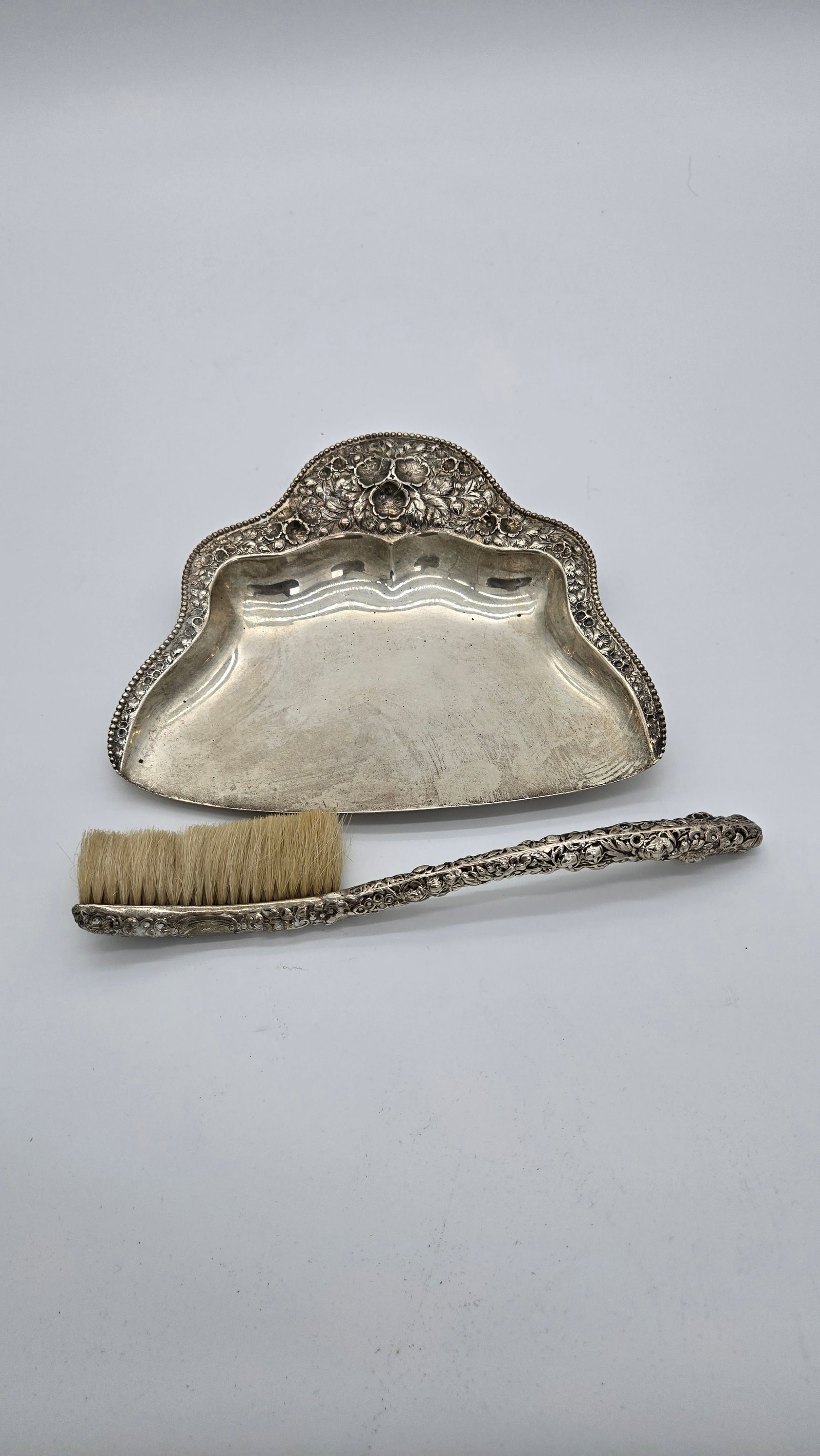 A STERLING SILVER REPOUSEE CRUMB PAN AND BRUSH. American, c. 1880 (1 of 5)