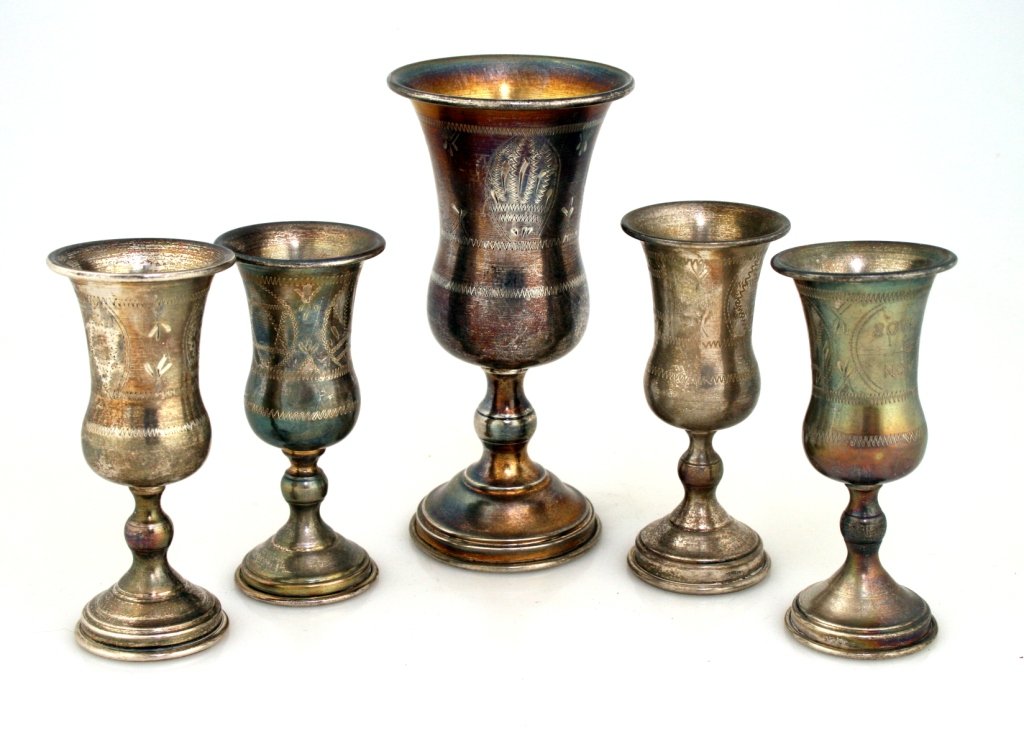 A SET OF FIVE STERLING SILVER KIDDUSH CUPS. United Stat: A SET OF FIVE STERLING SILVER KIDDUSH CUPS. United States, c.1920. With one very large and 4 smaller. 5.7” tall and 4.2” tall.