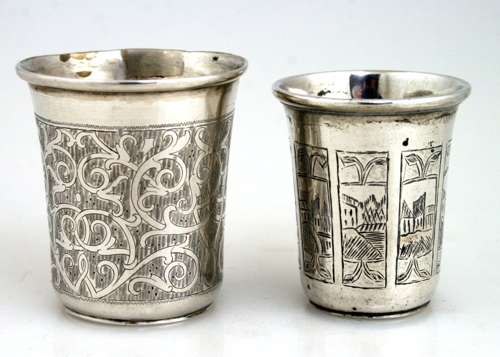 TWO SILVER BEAKERS. Russian, 19th century. The first, 2: TWO SILVER BEAKERS. Russian, 19th century. The first, 2”, is engraved with shetetel scenes, the second, 2.2” is engraved with scrolling work. Marked.