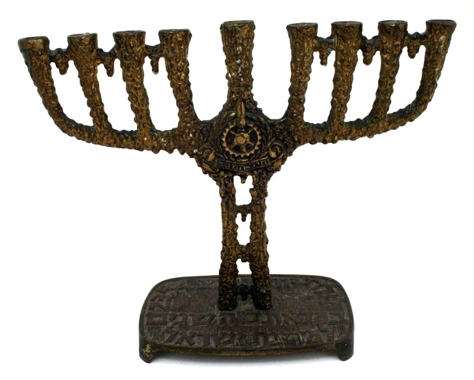 A BRASS MENORAH CELEBRATING THE 25 YEAR OF ISRAEL.: A BRASS MENORAH CELEBRATING THE 25 YEAR OF ISRAEL. Israel, 1973. Cast, with Hebrew wording on base. 8.5" long. Estimate $50 - 75