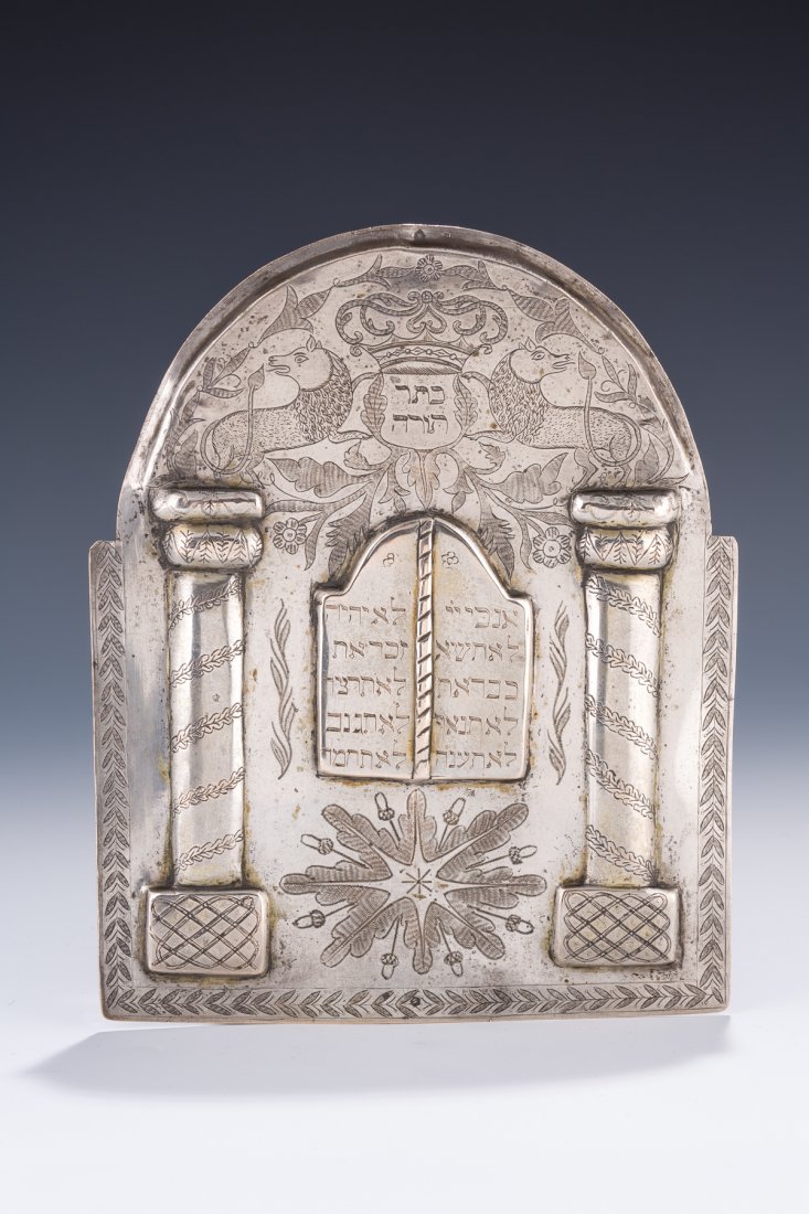 A SILVER TORAH SHIELD. Ukrainian, c. 1850. Chased with: A SILVER TORAH SHIELD. Ukrainian, c. 1850. Chased with two Solomonic columns and the Decalogue. Engraved with two outwardly facing lions flanking a central cartouche. Marked with later Hungarian marks