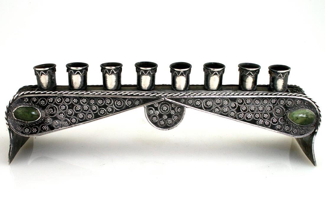 A SILVER MENORAH. Jerusalem, c. 1930. Decorated with: A SILVER MENORAH. Jerusalem, c. 1930. Decorated with applied stones and silver applications. 8.5” wide.