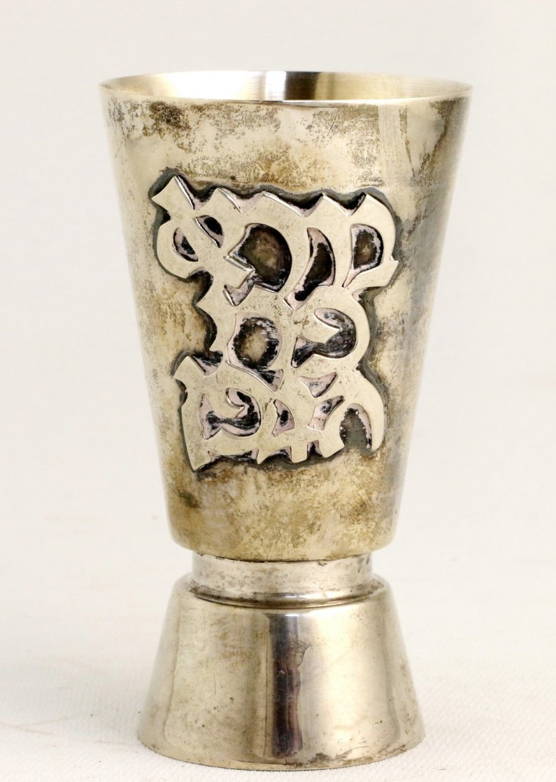 A STERLING SILVER KIDDUSH CUP. Israel, c. 1980. In: A STERLING SILVER KIDDUSH CUP. Israel, c. 1980. In modern design. With application for the blessing over wine. 4.1Ó tall.
