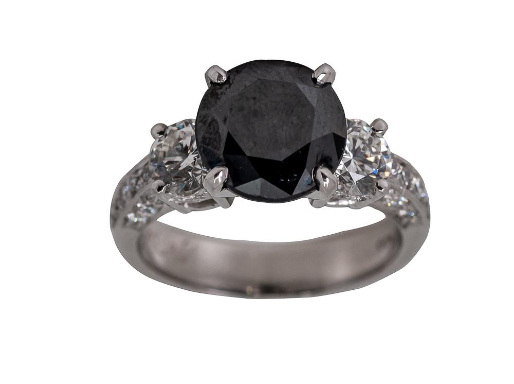 PLATINUM, BLACK DIAMOND, & DIAMOND RING: containing one black round brilliant cut diamond weighing approximately 2.85 carats, and 1.20 carats of accent diamonds; stamped 'J B Star PT 900' 8.5 grams size: 5 3/4