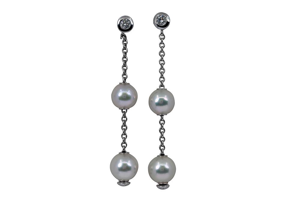 MIKIMOTO 18 KARAT WHITE GOLD, PEARL, & DIAMOND EARRINGS: containing four bright white cultured pearls measuring approximatley 7.00-7.50 mm, and two accent diamonds [F-G/VS] weighing approximately 0.14 carats total 4.9 grams 1 3/4 inches long
