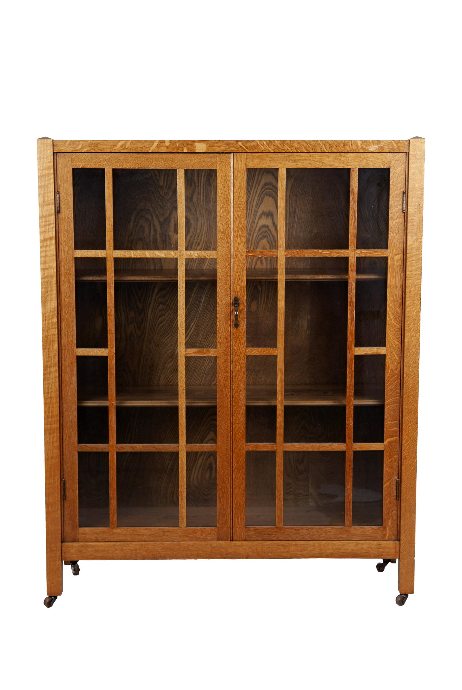 STICKLEY STYLE CARVED OAK BOOKCASE: set atop four casters Condition: some surface scratches to front, rear needs to have board re-attached, glass front in good condition 41 1/8 inches wide; 12 1/4 inches deep; 52 inches high