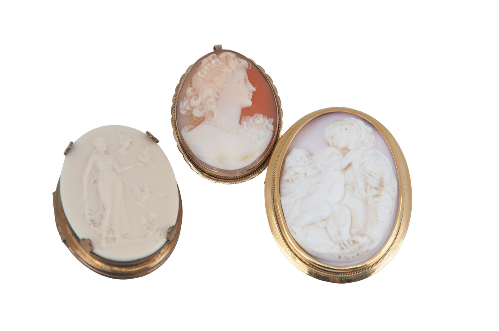 THREE CAMEO BROOCHES: two carved shell and one resin cameos. Condition: good overall condition. Mounted in 12k, 18k gold and base metal.