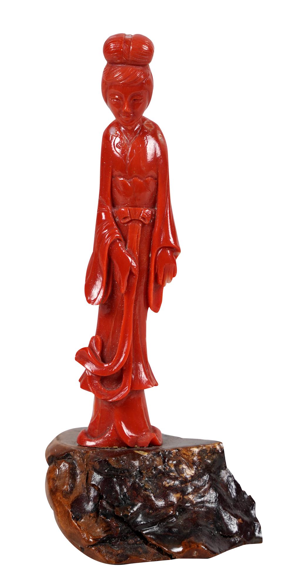 CARVED CORAL GUAN YIN: on wooden base the figure: 4 inches high: 5 total inches high including base Condition: the head attached to the body with a steel pin. There is separation between the head and the body. The figure is