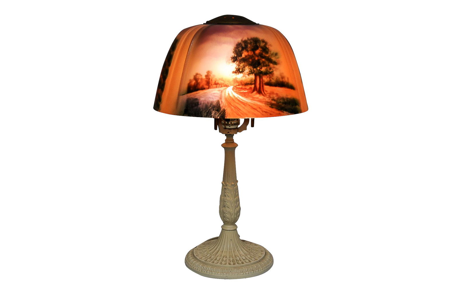 PITTSBURGH LAMP BRASS & GLASS CO. LANDSCAPE TABLE LAMP: circa 1900-1925 reverse painted partial-textured and ribbed shade with a painted iron foliate base shade depicting a country road in a landscape base stamped PLB & GCO underside Condition: shade with