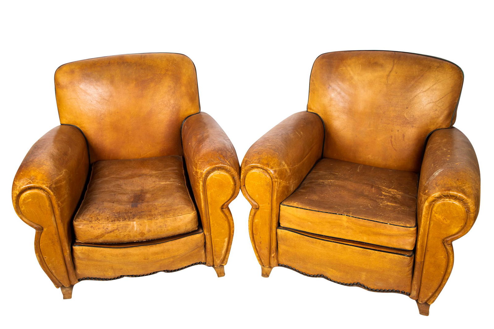 PAIR OF ART DECO LEATHER CLUB CHAIRS: with ribbed arms and brass tacks Condition: heavily worn; with heavy losses and gashes to leather throughout; seat falling out underside on each 32 inches high
