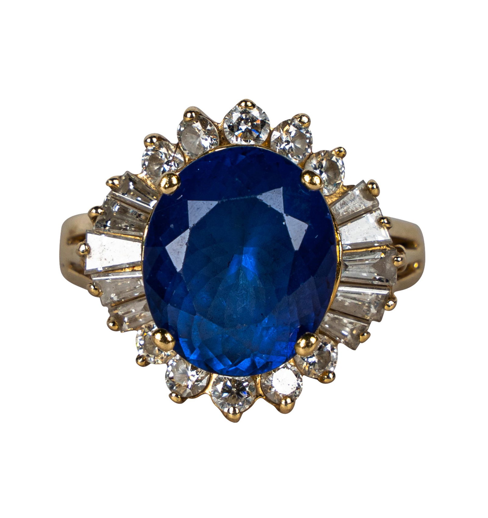 14 KARAT YELLOW GOLD, DIAMOND, & TANZANITE RING: centering one oval cut natural tanzanite weighing approximately 5.28 carats; ten tapered baguette cut diamonds [H/VVS] weighing approximately 0.82 carats total; and ten full cut diamonds [H/VS] weighi